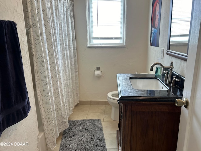 bathroom with tile patterned flooring, plenty of natural light, toilet, and vanity