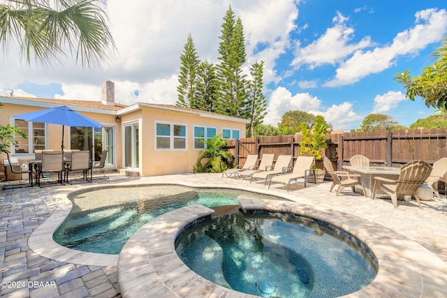 view of swimming pool with an in ground hot tub and a patio