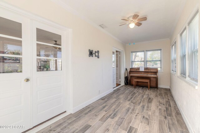 unfurnished sunroom featuring ceiling fan