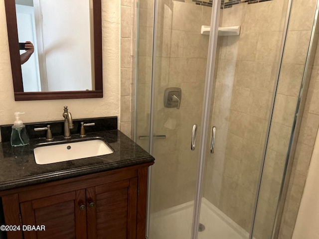 bathroom with vanity and a shower with door