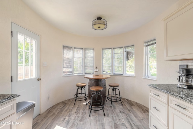 dining room with light wood-type flooring and a healthy amount of sunlight