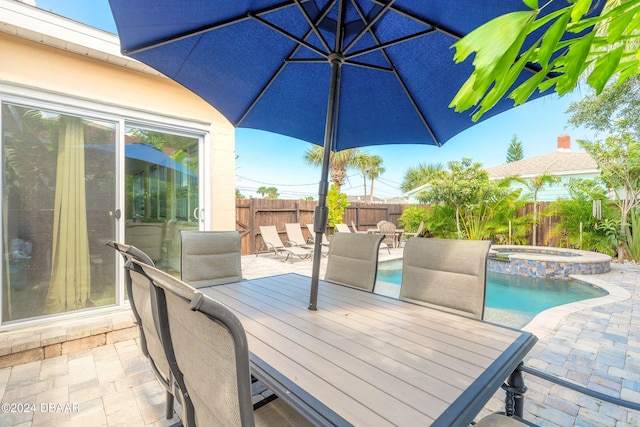 view of patio featuring a swimming pool with hot tub