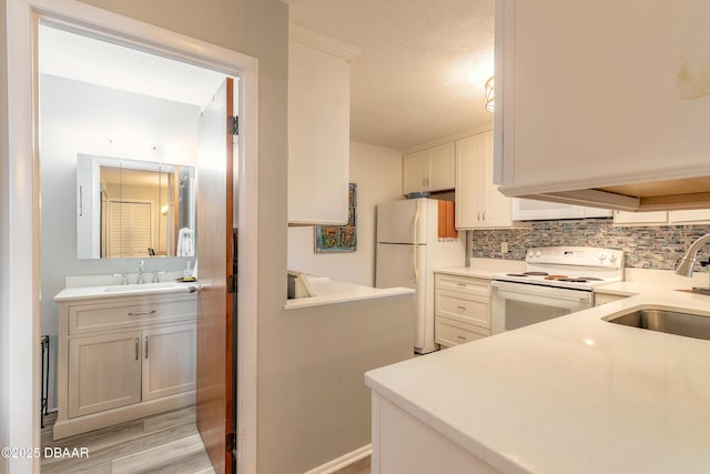 kitchen with white appliances, light hardwood / wood-style floors, sink, and decorative backsplash