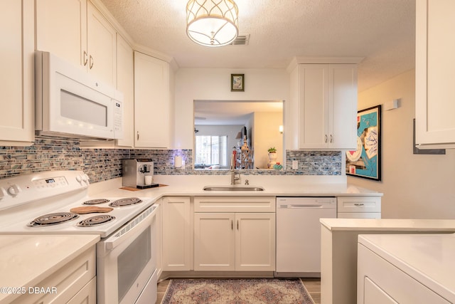 kitchen with sink, backsplash, white cabinets, white appliances, and a textured ceiling