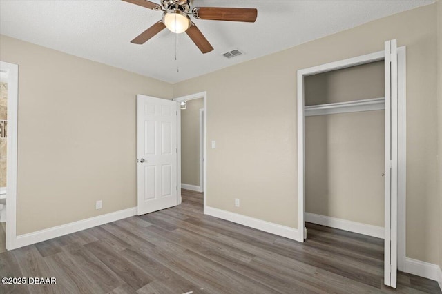 unfurnished bedroom featuring wood-type flooring, a closet, and ceiling fan