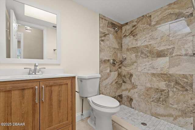 bathroom featuring vanity, toilet, and a tile shower