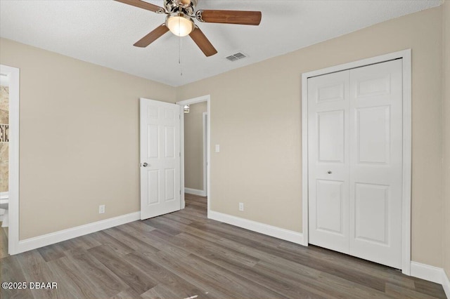 unfurnished bedroom with hardwood / wood-style flooring, ceiling fan, and a closet