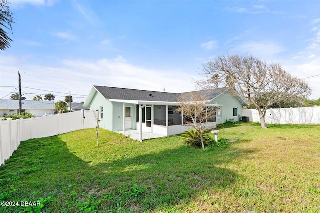 rear view of property with a sunroom, a yard, and a patio