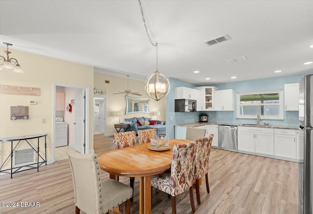 dining area with washer / clothes dryer, light hardwood / wood-style flooring, ceiling fan, and sink