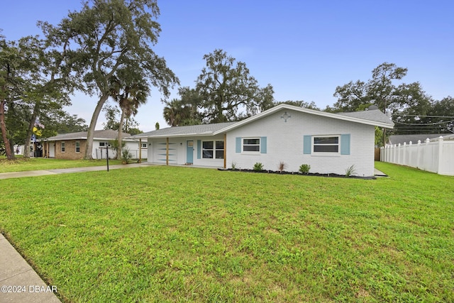 ranch-style house featuring a garage and a front lawn