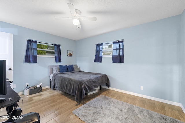 bedroom featuring multiple windows, ceiling fan, and light wood-type flooring