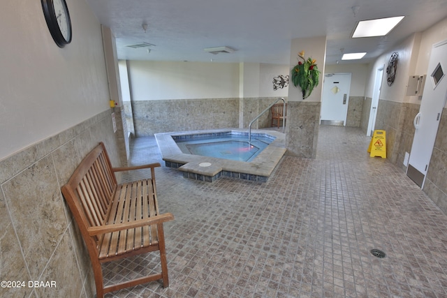 view of pool with an indoor hot tub and a skylight