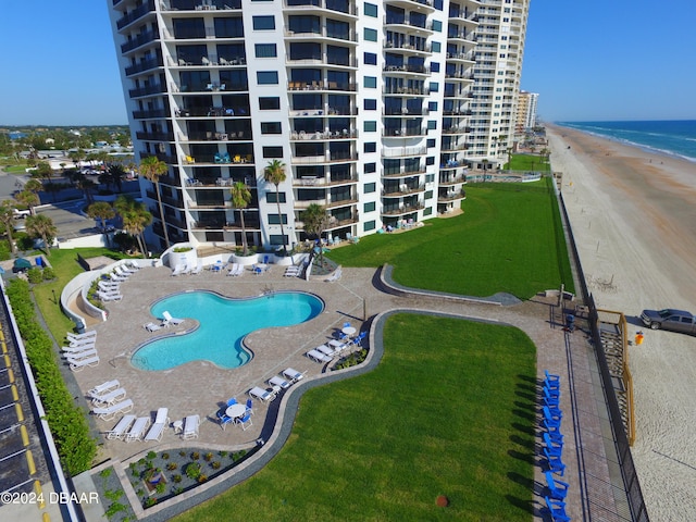 view of swimming pool with a patio, a water view, and a lawn