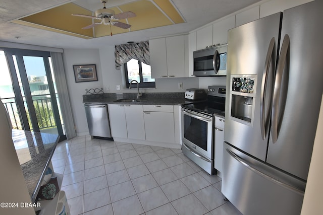 kitchen featuring white cabinetry, appliances with stainless steel finishes, dark stone counters, and sink