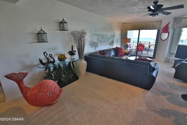 carpeted living room with a water view and ceiling fan