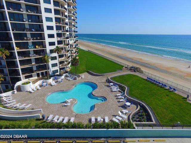 view of pool with a view of the beach, a water view, and a patio