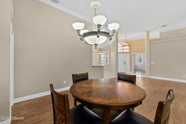 dining room featuring hardwood / wood-style flooring, crown molding, and an inviting chandelier