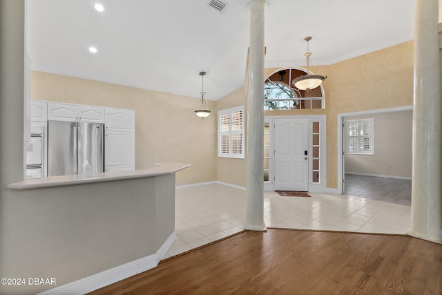 foyer with light hardwood / wood-style floors and high vaulted ceiling