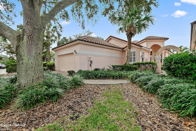 mediterranean / spanish-style house with a garage