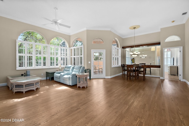 living room with crown molding, wood-type flooring, and ceiling fan with notable chandelier