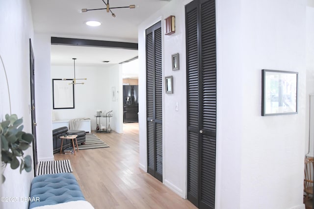 hall with a chandelier, light wood-type flooring, baseboards, and recessed lighting