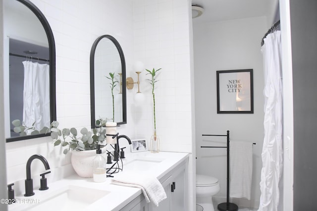 bathroom with double vanity, toilet, and decorative backsplash