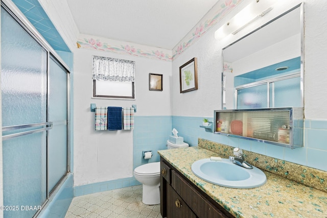 full bathroom featuring bath / shower combo with glass door, toilet, and vanity