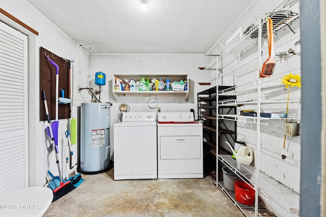 laundry room featuring a textured ceiling, washing machine and dryer, and water heater