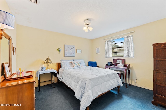 bedroom with ceiling fan and dark carpet