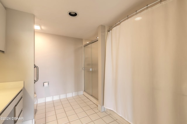 bathroom with tile patterned floors, walk in shower, vanity, and toilet