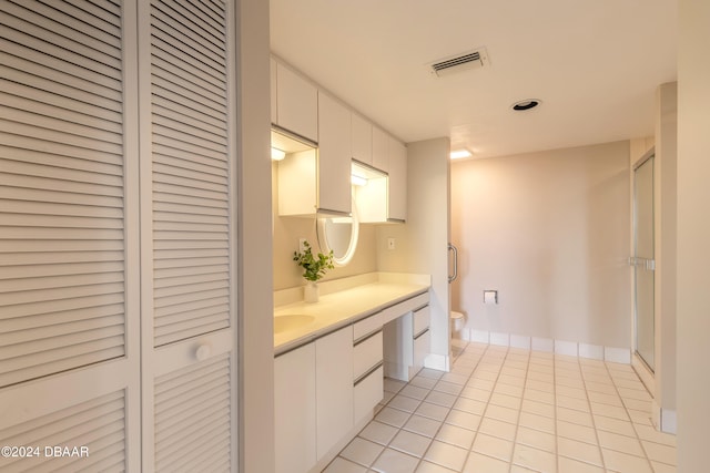 bathroom with tile patterned floors, vanity, toilet, and walk in shower