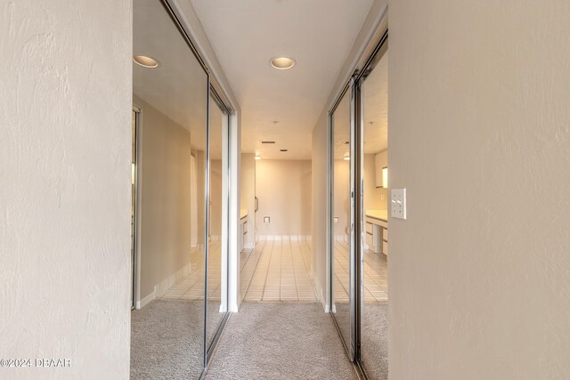 hallway with light colored carpet