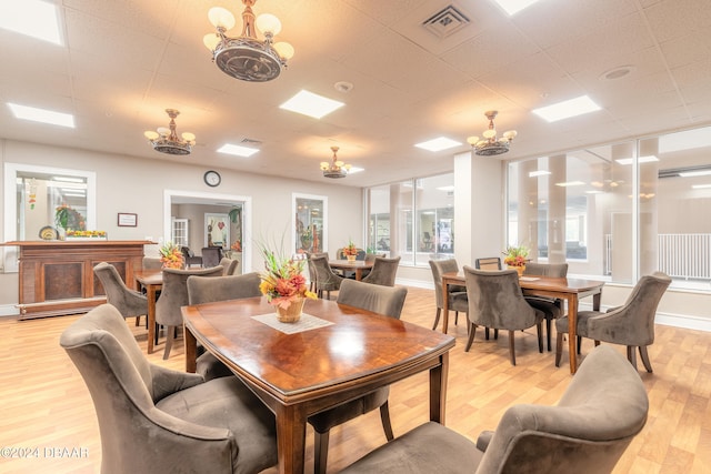 dining space with a notable chandelier and light wood-type flooring