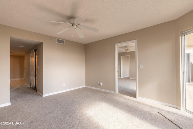 spare room featuring ceiling fan, carpet floors, and a textured ceiling