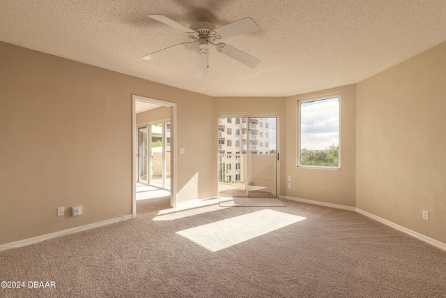 unfurnished room featuring ceiling fan, light colored carpet, and a textured ceiling