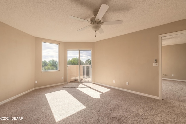 empty room featuring light carpet, ceiling fan, and a textured ceiling