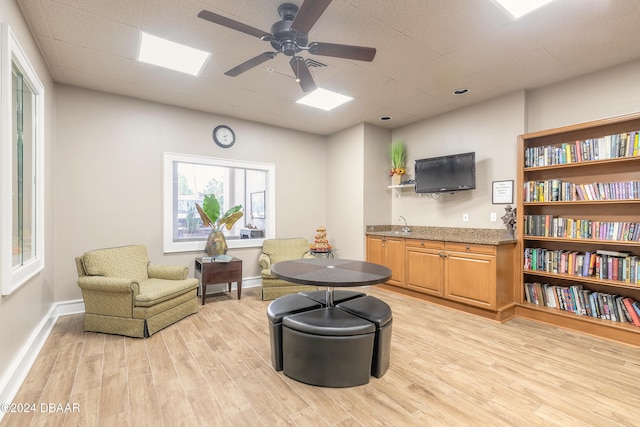 living area featuring light wood-type flooring and ceiling fan