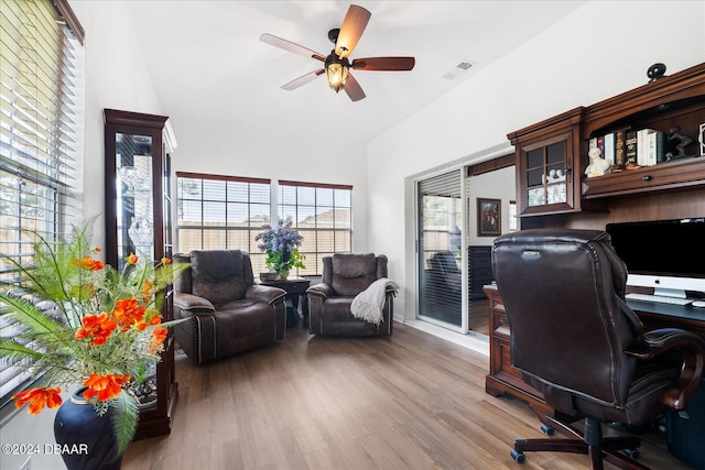 home office with ceiling fan, vaulted ceiling, and light wood-type flooring