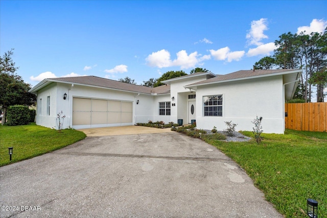 ranch-style home with a garage and a front lawn