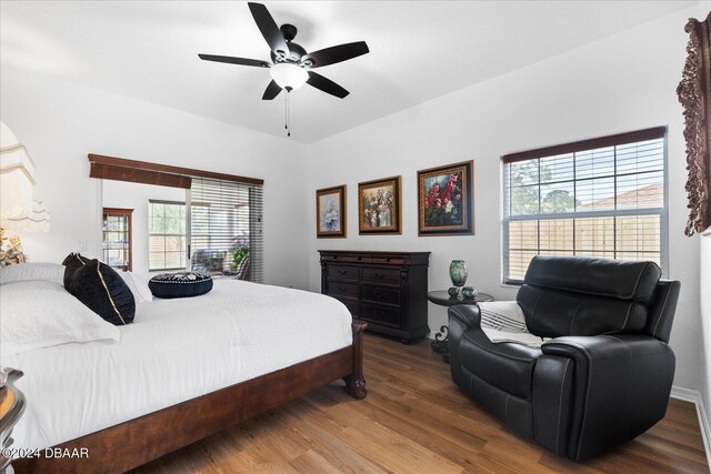 bedroom with hardwood / wood-style flooring, ceiling fan, and multiple windows