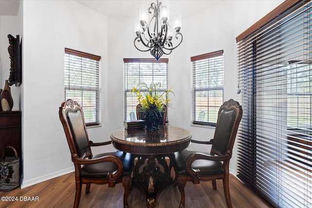 dining room with dark hardwood / wood-style floors and an inviting chandelier