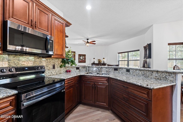 kitchen featuring light hardwood / wood-style floors, sink, kitchen peninsula, and stainless steel appliances