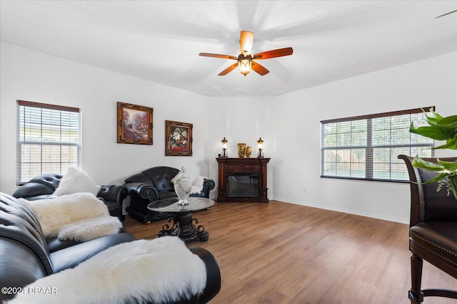 living room with plenty of natural light, ceiling fan, and light hardwood / wood-style flooring