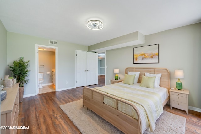 944 S Peninsula Dr Unit 104, Daytona Beach, FL 32118 - bedroom featuring dark wood-style floors, baseboards, ensuite bathroom, and a closet