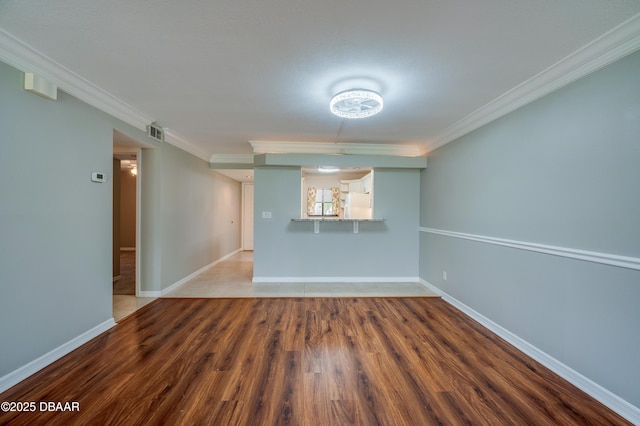 944 S Peninsula Dr Unit 104, Daytona Beach, FL 32118 - spare room with wood finished floors, ornamental molding, and baseboards