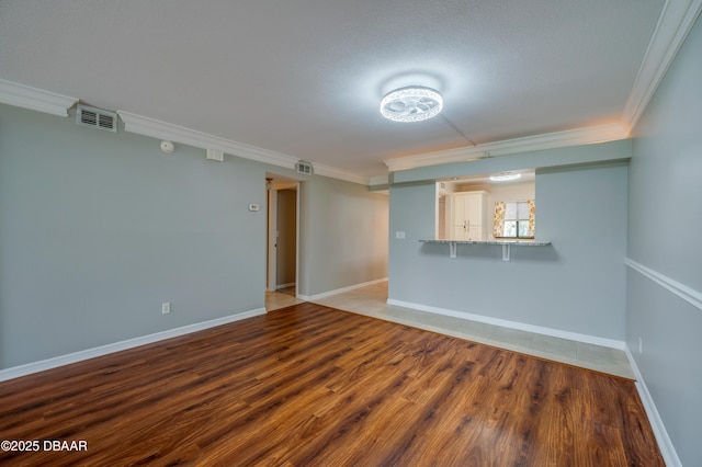 944 S Peninsula Dr Unit 104, Daytona Beach, FL 32118 - unfurnished living room with ornamental molding, light wood-style floors, and baseboards