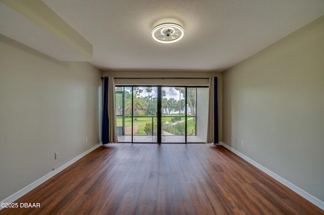 944 S Peninsula Dr Unit 104, Daytona Beach, FL 32118 - unfurnished room with baseboards and dark wood-style flooring