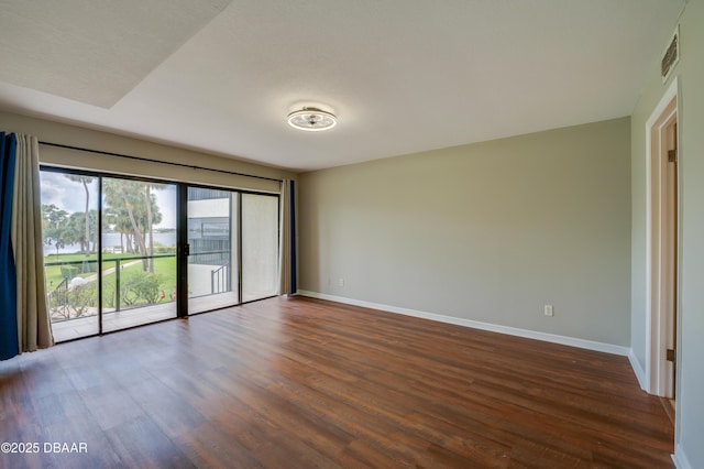 944 S Peninsula Dr Unit 104, Daytona Beach, FL 32118 - unfurnished room with baseboards and dark wood-style flooring