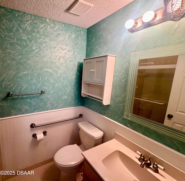 528 Crooked Stick Dr, Daytona Beach, FL 32114 - bathroom with wainscoting, wallpapered walls, vanity, and a textured ceiling