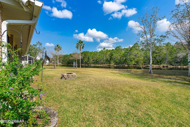 view of yard featuring a water view and an outdoor fire pit